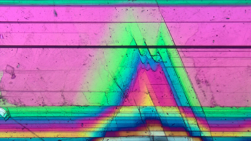 Mikrofoto eines Gips-Einkristalls zeigt knallige Farbverläufe. © Julian Portenkirchner