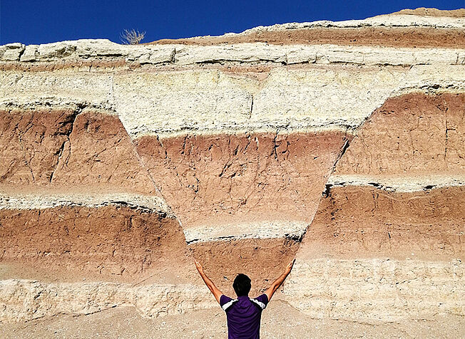 Person lifting his arms in front of the "normal fault"