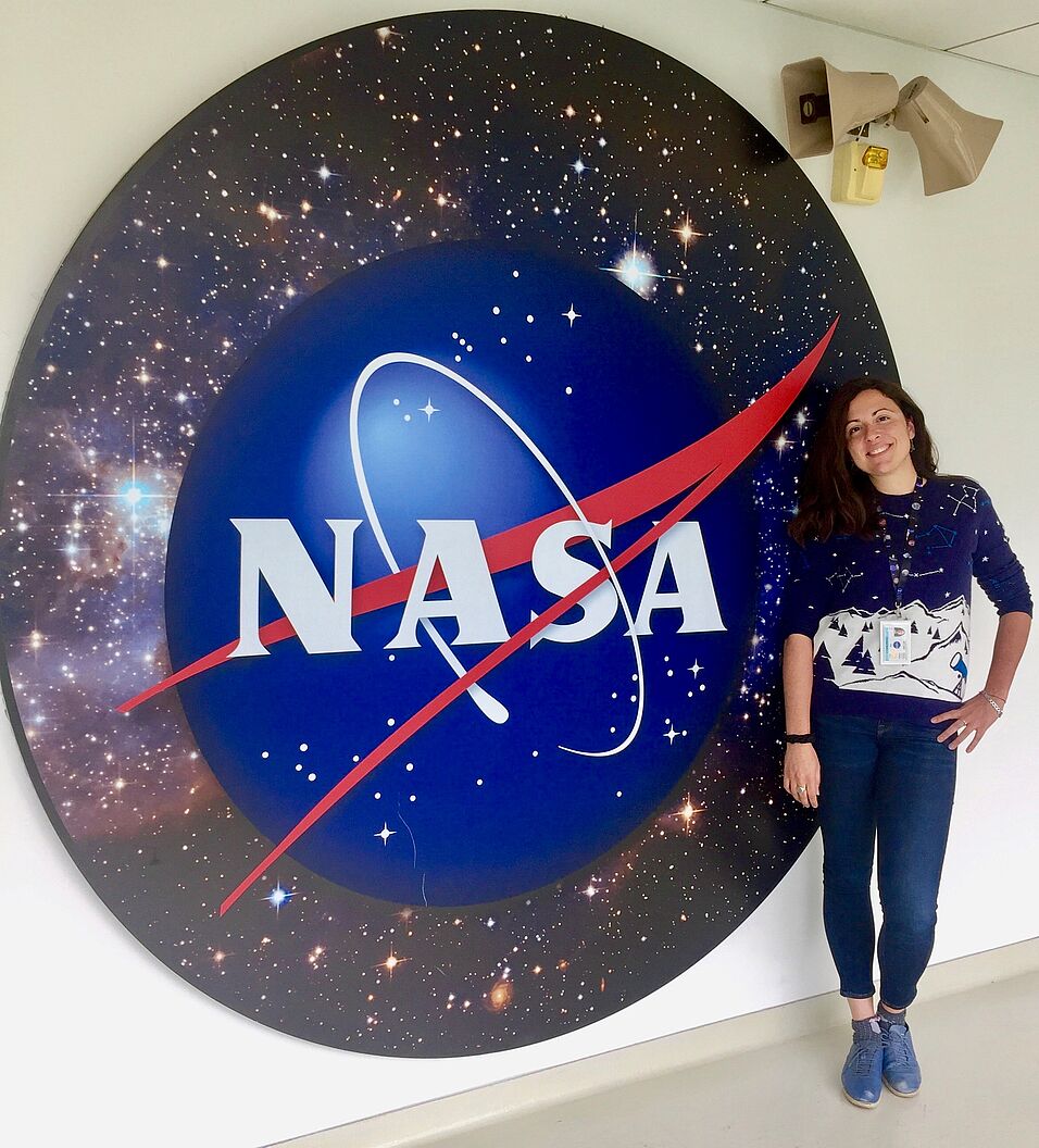 Scientist Gioia Rau in front of NASA logo